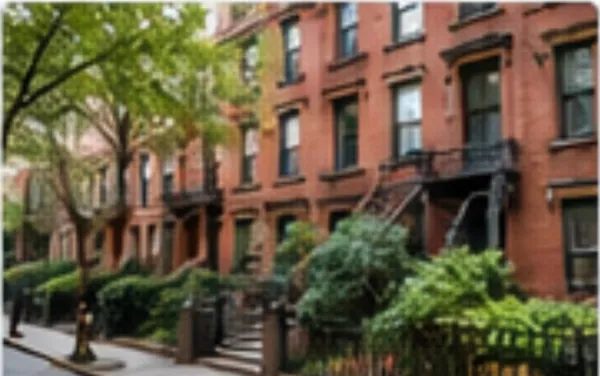 Brownstone style buildings on a tree lined New York street (illustrative image)